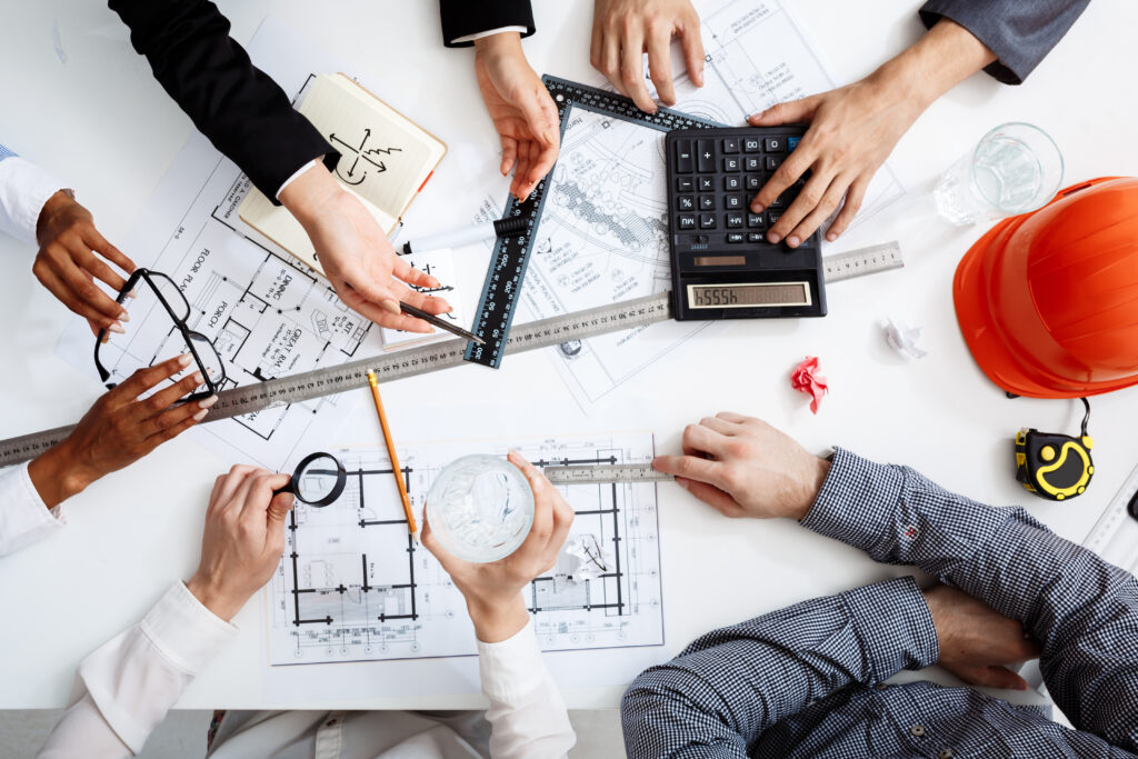 Picture of businessmen's hands on white table with documents and drafts
